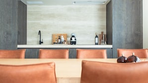 A modern kitchen with a central island, a built-in oven, and a coffee machine.