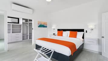 Un dormitorio con cama, mesitas de noche, armario y aire acondicionado.