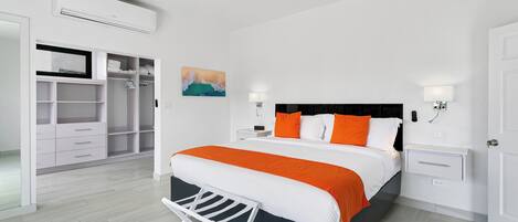 A bedroom with a bed, bedside tables, a wardrobe, and an air conditioning unit.