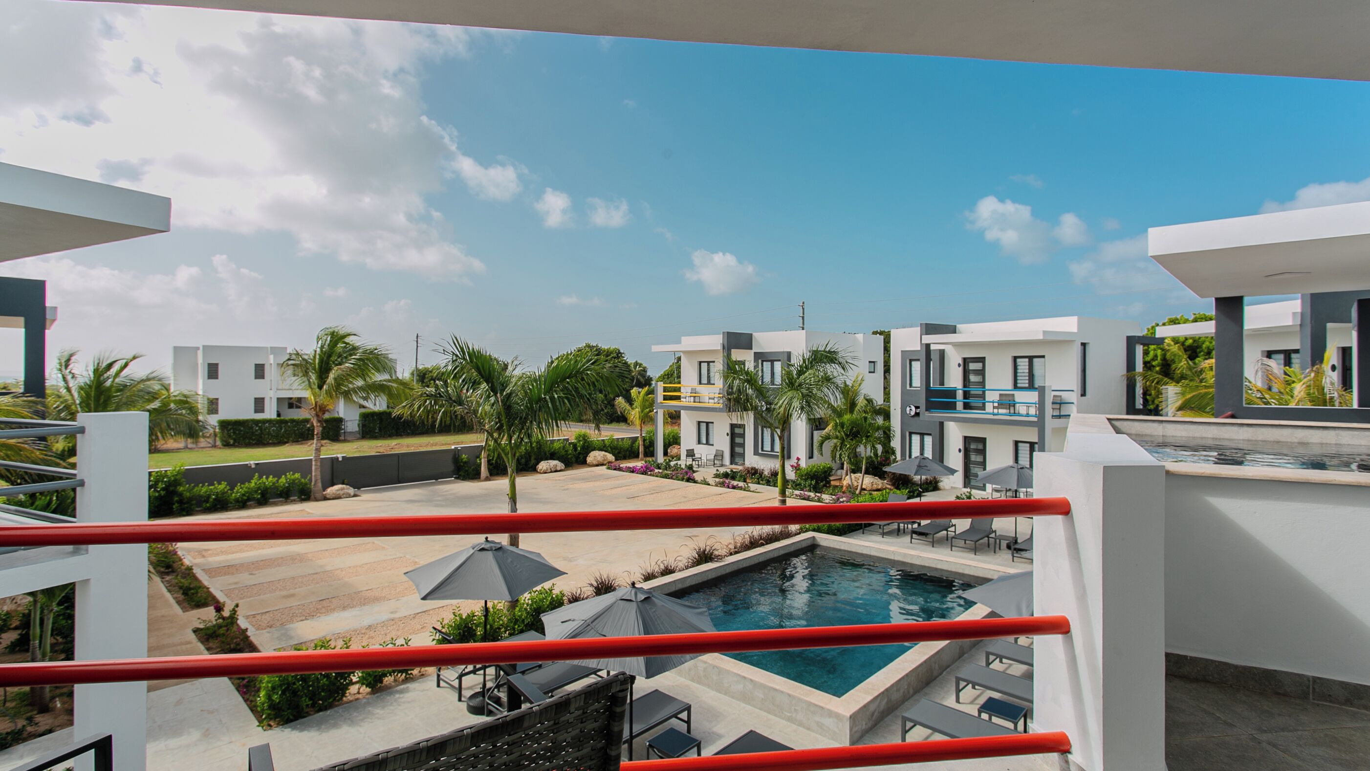 Un hotel moderno con piscina en la azotea, asientos al aire libre y vistas a edificios cercanos.