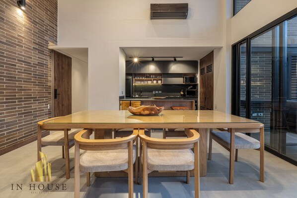 Una cocina moderna con una mesa de vidrio y sillas de madera.