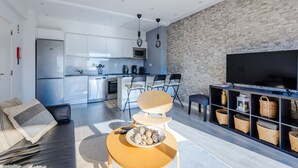 Una sala de estar moderna con un sofá, una mesa de centro y un mueble para televisión con cestas.
