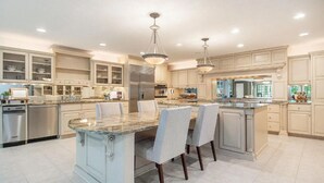 A spacious kitchen with granite countertops, stainless steel appliances, and a central island with seating.