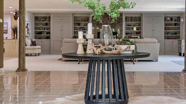 A spacious living area with a round coffee table, a sofa, and a decorative plant centerpiece.