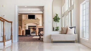 A spacious living room with a fireplace, a large mirror, and a comfortable seating area.