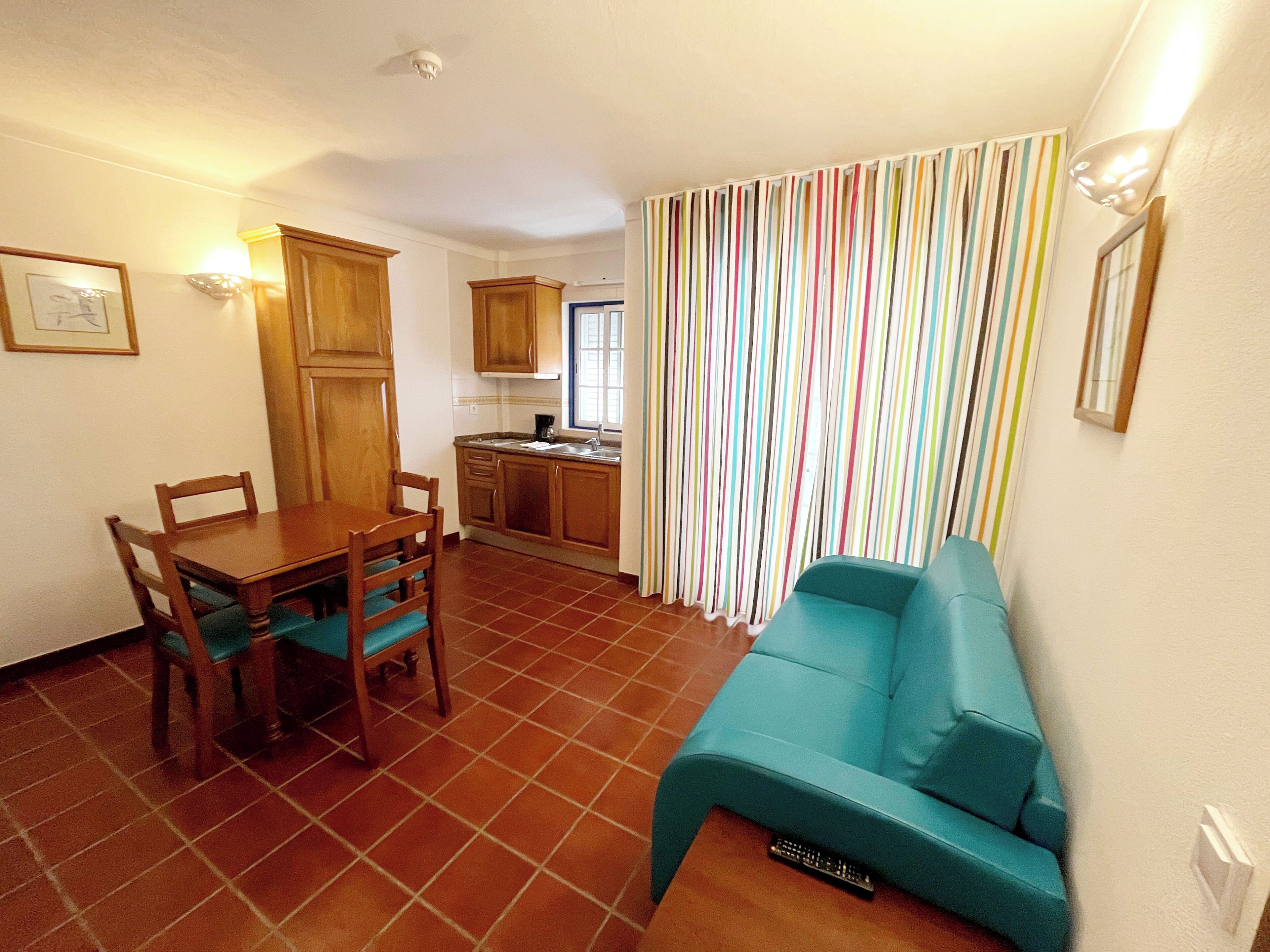 Un espacio habitable compacto con comedor, kitchenette y sofá.