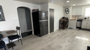 A modern kitchen with a refrigerator, stove, and dining area. - Charming 2-bedroom house with WiFi, AC in enjoyable Lancaster (Lancaster)