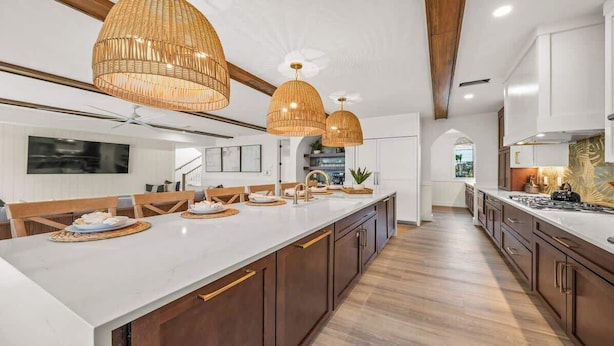 A modern kitchen with a large island, wooden cabinets, and pendant lighting. - New - Private Beach Access - Pool Bar/Volleyball (Sarasota)