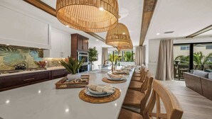 A spacious kitchen with a long island, modern appliances, and a view to the outdoors. - New - Private Beach Access - Pool Bar/Volleyball (Sarasota)