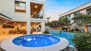 A two-story building with a swimming pool, outdoor seating, and a basketball hoop. - New - Private Beach Access - Pool Bar/Volleyball (Sarasota)