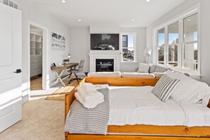 Et moderne soveværelse med en stor seng, et skrivebord og en pejs.