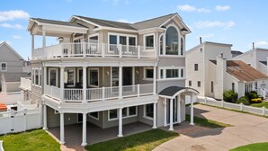 A two-story house with a balcony, a covered porch, and a driveway. - Heated Pool Hot Tub 5BR Game Room Elevator Cabana (Brigantine)