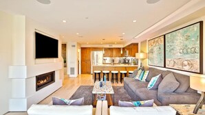 A modern living room with a fireplace, a sofa set, a coffee table, and a TV mounted on the wall.