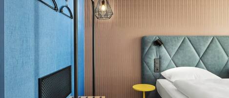 Un dormitorio con cama, mesita de noche, lámpara colgante y radiador.