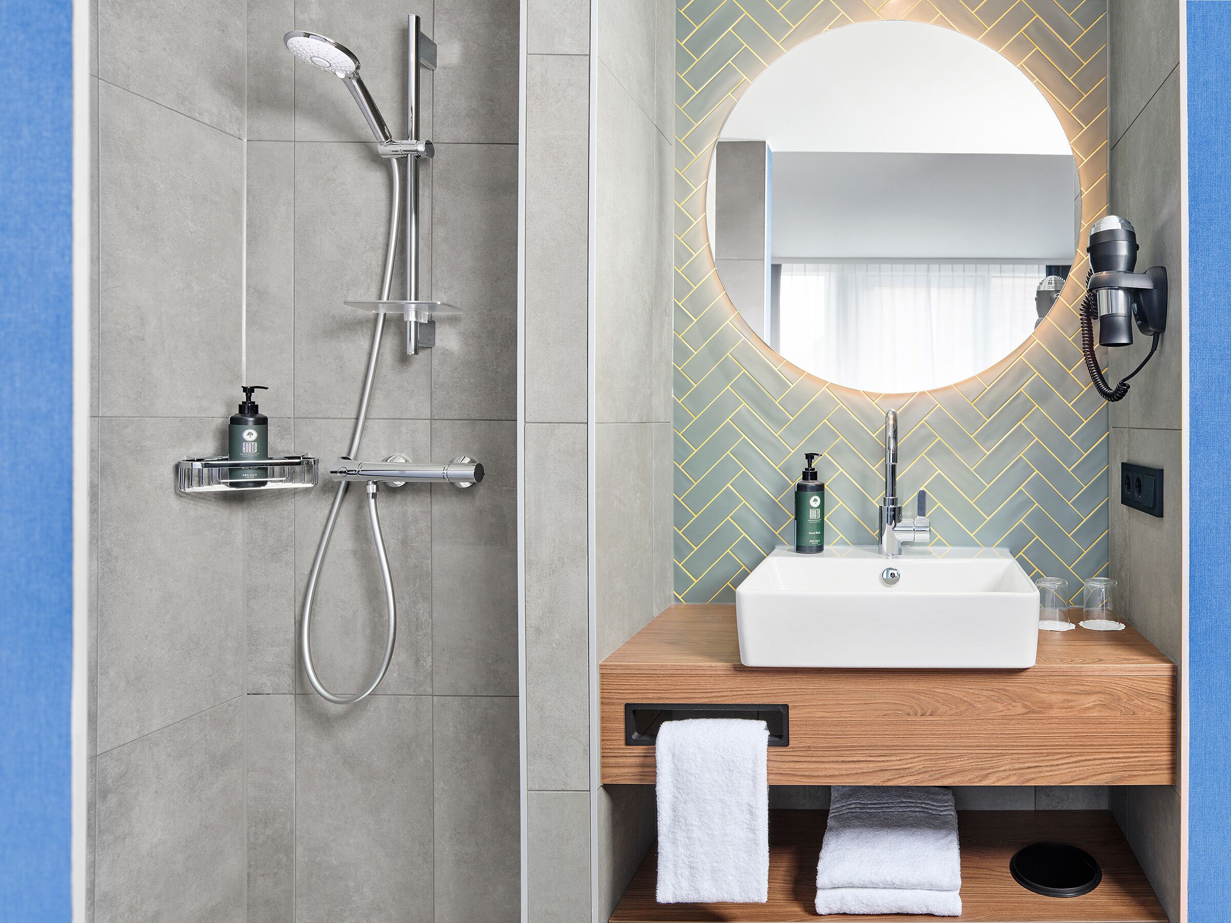 A modern bathroom with a shower, a sink, and a mirror.