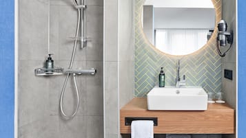 A modern bathroom with a shower, a sink, and a mirror.