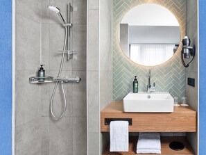 A modern bathroom with a shower, a sink, and a mirror. - Hotel Erfurt-City (Erfurt)