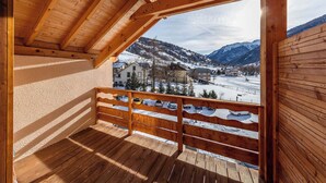 Ein Holzbalkon mit Blick auf eine verschneite Bergstadt.