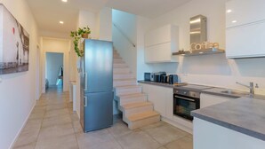 Eine moderne Küche mit Einbauofen, Edelstahlkühlschrank und einer Kaffeestation.