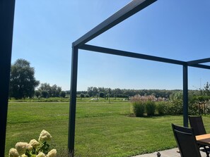 Enjoy dining or relaxing under the shelter with a view of the well-maintained lawn and distant trees.