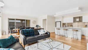 A modern apartment with a living room, dining area, and kitchen.