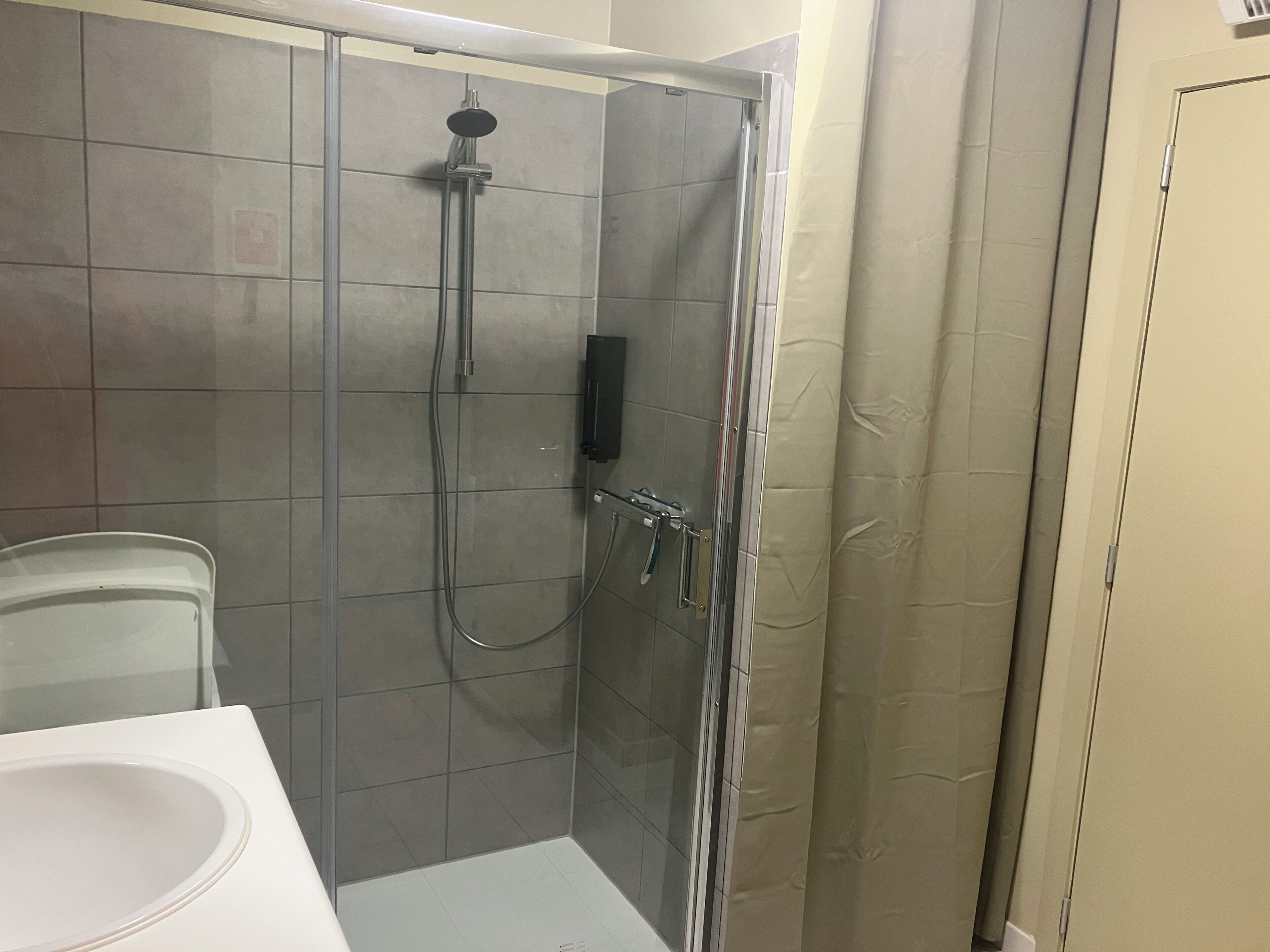 Un baño con cabina de ducha, inodoro y lavamanos.