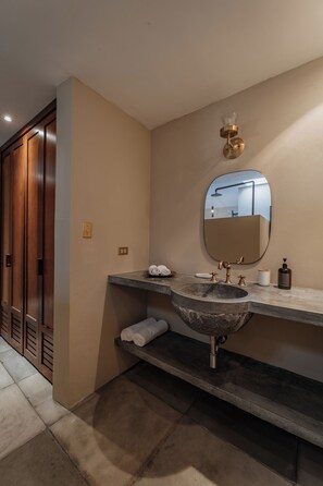 A bathroom with a large oval mirror, a granite sink, and a towel rack. - Casa Exclusiva Los Amigos, 4BDR by Cercana (Mérida)
