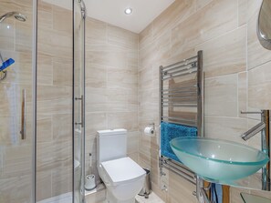 A modern bathroom with a glass-enclosed shower, a toilet, and a glass bowl sink. - 2 bedroom accommodation in Paignton (Paignton)