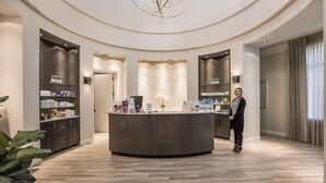 A modern reception area with a central counter, shelves with products, and a circular ceiling design. - Enjoy Resort living in the Upscale Lakewood National Golf Country Club community (Bradenton)