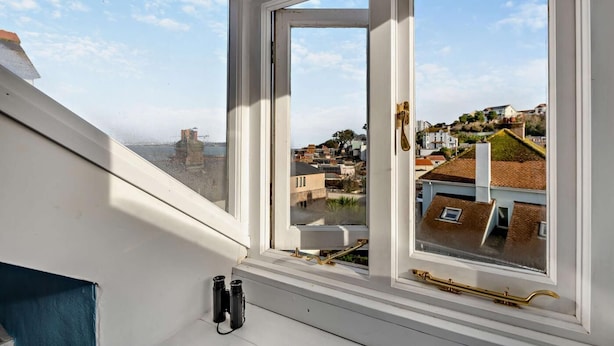 A room with a large window overlooking a hillside town. - 2 Bed in Brixham (oc-p30465) (Brixham)
