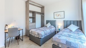 Een slaapkamer met twee bedden, een bureau en een stoel.
