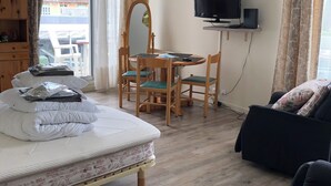 A hotel room with a bed, a desk with a chair, a TV, and a sofa. - T1 33m very bright, elevator, balcony, private parking, close to shops (Bagnoles de l'Orne Normandie)