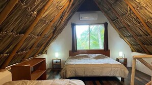 Une chambre avec deux lits, un plafond en bois, une fenêtre avec des rideaux et un appareil de climatisation.
