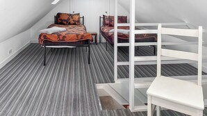 Ein Schlafzimmer mit einem Etagenbett, einem Einzelbett und einem Sessel.
