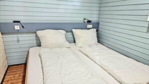 A single bed with white bedding in a room with light blue walls and a wooden floor. - Small country house 2B in the Westerwald. Family-friendly, pet-friendly and close to nature (Welschneudorf)