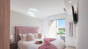 A bedroom with a bed, bedside table, and a window.