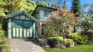 A two-story house with a green garage and a stone staircase leading to the front door. - Ferntree Cottage in Blackheath (Blackheath)