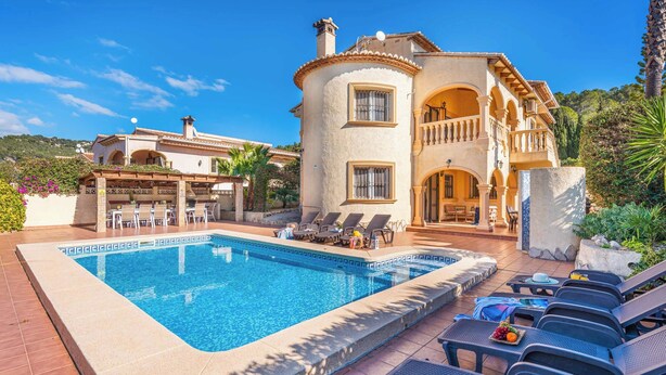 Un área junto a la piscina con piscina, sillas de descanso y un comedor con mesas al aire libre.