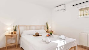 Una habitación de hotel ordenada con cama, mesitas de noche y ventana.