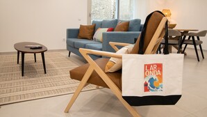 A living room with a sofa, a chair, a small table, and a rug. - Lar da Onda - By SCH (Nazaré)