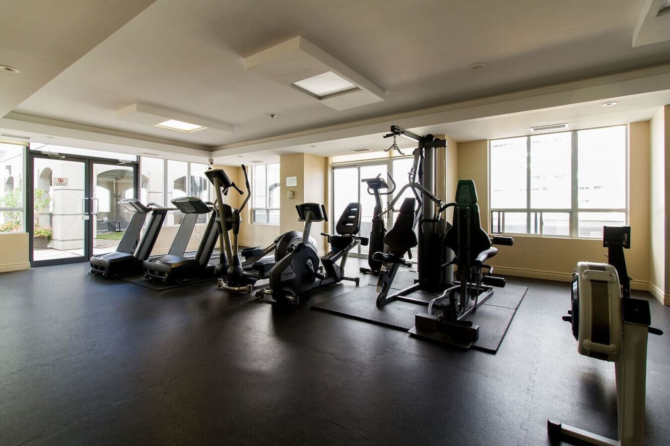 A gym with treadmills, elliptical machines, and weight equipment.