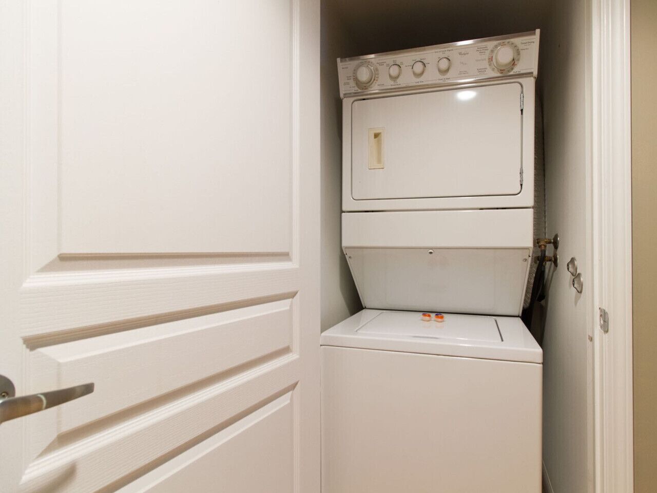A compact laundry room with a stacked washer and dryer.