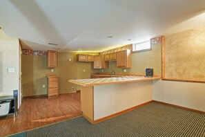 A compact kitchen with wooden cabinets, a small island, and a built-in microwave.