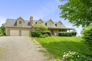 A two-story house with a covered porch, a garage, and a well-maintained lawn.