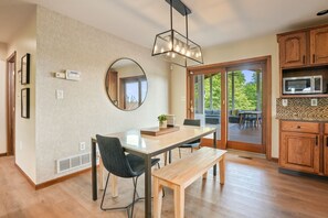 A modern kitchen with wooden cabinets, a built-in microwave, and a large window.