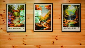 Tres carteles enmarcados del Parque Estatal Hocking Hills sobre una pared de madera.