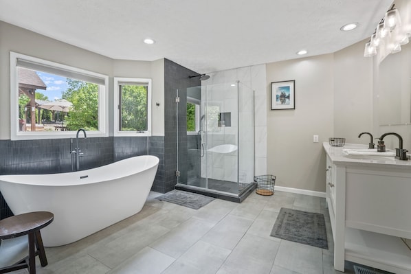 A modern bathroom with a freestanding bathtub, a glass-enclosed shower, and a vanity with a sink.