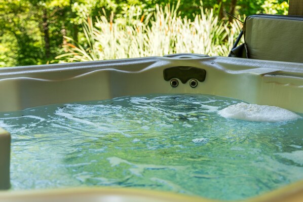 Un bain à remous avec vue sur un paysage verdoyant en arrière-plan.