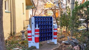 Una barrera azul y blanca con franjas rojas y blancas, un lavadero de piedra para pájaros y un sendero que lleva a un edificio.