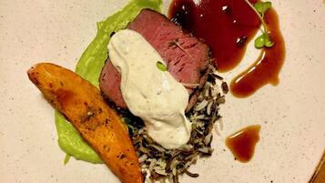 En tallerken med bøf, flødesauce, ris og en lille portion sauce.